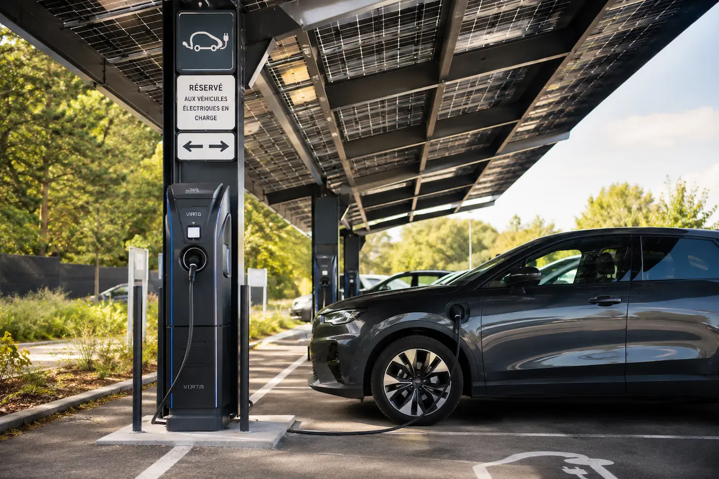 Borne de recharge pour véhicule électrique installée sous une ombrière photovoltaïque de parking